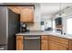 Kitchen boasts stainless steel appliances, sink with backsplash, and wood cabinets at 1680 Arbor Springs Dr, Brownsburg, IN 46112