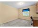This bedroom has neutral carpeting and a window providing natural light and backyard view at 1817 Edgewood Dr, Anderson, IN 46011