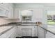 Bright kitchen featuring white cabinets, granite countertops, and stainless steel appliances, offering a modern cooking space at 1817 Edgewood Dr, Anderson, IN 46011