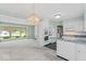 Well-lit kitchen featuring white appliances, granite countertops, and an adjacent living area at 1817 Edgewood Dr, Anderson, IN 46011