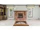 Comfortable living room showcasing a brick fireplace, large windows, and charming built-in features at 1817 Edgewood Dr, Anderson, IN 46011