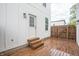 An outdoor back deck entrance featuring wooden floors, a white door, and a fenced in backyard at 1825 E Maryland St, Indianapolis, IN 46201