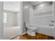 View of a bathroom with a white tiled bathtub and toilet, as seen from an adjacent carpeted room at 1825 E Maryland St, Indianapolis, IN 46201