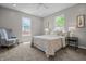 Cozy bedroom with neutral decor, large windows providing natural light, and a comfortable armchair at 1825 E Maryland St, Indianapolis, IN 46201