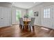 Bright dining room with a wooden table, gray upholstered chairs, and natural light streaming through large windows at 1825 E Maryland St, Indianapolis, IN 46201