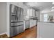 Open-concept kitchen featuring stainless steel refrigerator, white cabinets, and a view to the living area at 1825 E Maryland St, Indianapolis, IN 46201