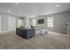 Cozy living room with a gray sofa, carpeted floors, and a wall-mounted TV for comfortable and modern living at 1825 E Maryland St, Indianapolis, IN 46201