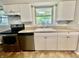 A kitchen features stainless steel appliances, tiled backsplash, and white cabinetry at 1927 E 125 S, Franklin, IN 46131