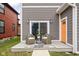 Cozy back porch with outdoor seating, a sliding glass door, and an orange door at 2024 Yandes St, Indianapolis, IN 46202