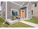 Charming back porch with a sliding glass door, orange door, and wicker furniture at 2024 Yandes St, Indianapolis, IN 46202