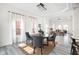 Bright dining area open to the living room features a round table with gray chairs and light wood floors at 2024 Yandes St, Indianapolis, IN 46202