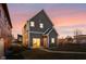 Two story home illuminated at dusk with gray siding, bright entry door, and landscaped yard at 2024 Yandes St, Indianapolis, IN 46202