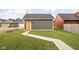 Garage with gray siding and bright door, with walkway and green grass at 2024 Yandes St, Indianapolis, IN 46202