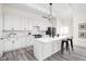 Bright kitchen with white cabinets, large island, sleek lighting, and stainless steel refrigerator at 2024 Yandes St, Indianapolis, IN 46202