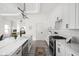 Open kitchen layout with white cabinetry, modern hardware, and view into a sunlit living space at 2024 Yandes St, Indianapolis, IN 46202