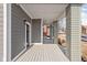 Spacious covered front porch with gray painted wood decking and support columns and sidelight view at 2024 Yandes St, Indianapolis, IN 46202