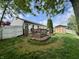 The backyard includes a wooden deck, lush lawn, shed, and perimeter fencing creating a charming and private outdoor space at 204 Meadow Creek S Dr, Whiteland, IN 46184