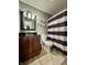 This bathroom has a wooden vanity and a black and white shower curtain at 204 Meadow Creek S Dr, Whiteland, IN 46184