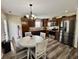 Bright eat-in kitchen features stainless appliances, dark wood cabinets, stylish lighting and wood flooring at 204 Meadow Creek S Dr, Whiteland, IN 46184