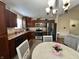 Bright eat-in kitchen features stainless appliances, dark wood cabinets, stylish lighting and wood flooring at 204 Meadow Creek S Dr, Whiteland, IN 46184