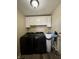 Functional laundry room featuring white cabinets and modern washer/dryer units at 204 Meadow Creek S Dr, Whiteland, IN 46184