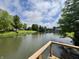 Serene pond view from a deck with wooden rails, offering a peaceful setting amidst lush greenery at 204 Meadow Creek S Dr, Whiteland, IN 46184