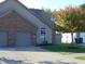 Charming home features a two-car garage, a well-maintained lawn, and a mature tree with colorful leaves at 2116 Galaxy Dr, Franklin, IN 46131