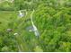 An aerial view showcasing the entire property, including the home, a long driveway, and surrounding greenery at 2935 N Grizzly Ln, Martinsville, IN 46151