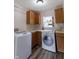 Bright laundry room with wooden cabinets, front load washer and dryer and a hanging bar at 2935 N Grizzly Ln, Martinsville, IN 46151