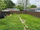 Backyard with patchy grass, wooden fence, trailer, and shed at 322 S Rural St, Indianapolis, IN 46201