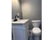 Bathroom with white vanity, black faucet, toilet, and gray walls at 322 S Rural St, Indianapolis, IN 46201