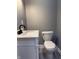 Modern bathroom with white vanity and toilet, featuring gray walls and luxury vinyl floors at 322 S Rural St, Indianapolis, IN 46201