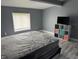 Bedroom featuring hardwood floors, a new mattress with gray walls, and a window at 322 S Rural St, Indianapolis, IN 46201