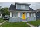Charming home with a bright yellow door, classic architectural details, and a well-maintained front yard at 322 S Rural St, Indianapolis, IN 46201
