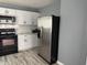 Modern kitchen featuring stainless steel refrigerator, microwave, and white cabinets at 322 S Rural St, Indianapolis, IN 46201