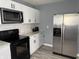 Modern kitchen featuring stainless steel refrigerator, microwave, and white cabinets at 322 S Rural St, Indianapolis, IN 46201