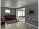 Open-concept living room with gray walls and flooring, leading to a dining area at 322 S Rural St, Indianapolis, IN 46201