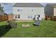 Large backyard featuring two swing chairs, green grass, and a brick fire pit at 3292 Underwood Dr, Whiteland, IN 46184