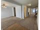 Spacious living room with neutral carpet, modern light fixture, and ample natural light, creating an inviting atmosphere at 3292 Underwood Dr, Whiteland, IN 46184