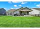 Rear view of house displaying the backyard, with a covered patio, grilling area, and ample space for activities at 3592 Gillsland Rd, Bargersville, IN 46106
