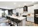Bright kitchen with an island, bar stools, stylish cabinets, black accents, and an open view to the dining area at 3592 Gillsland Rd, Bargersville, IN 46106