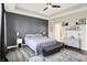 Bright main bedroom featuring a gray accent wall, light gray floors, tray ceiling, and a decorative area rug at 3592 Gillsland Rd, Bargersville, IN 46106