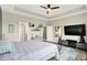 Spacious main bedroom with a large flatscreen TV, tray ceilings, modern ceiling fan, and an area rug at 3592 Gillsland Rd, Bargersville, IN 46106