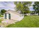Exterior view of a shed with green doors and a concrete slab, set in a grassy yard with a house in the background at 3642 S Mauxferry Rd, Franklin, IN 46131