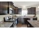 Well-equipped kitchen featuring dark cabinetry, countertops, and a window provides efficient space at 3832 Boundary Bay Dr, Indianapolis, IN 46217