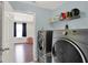 Bright laundry room with large appliances and a view of a room with hardwood floors at 3832 Boundary Bay Dr, Indianapolis, IN 46217