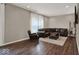 Inviting living room features dark wood floors, comfortable brown leather sofa, and natural light at 3832 Boundary Bay Dr, Indianapolis, IN 46217