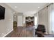 Open concept living room with dark wood flooring, a leather chair, and a view of the kitchen at 3832 Boundary Bay Dr, Indianapolis, IN 46217