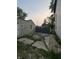 Backyard featuring detached garage, concrete, overgrown grass, and partially obscured view of a neighboring home at 4106 N Pasadena Ave, Indianapolis, IN 46226