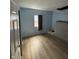 Bedroom featuring light blue walls, wood floors, a window with curtains, and some items on the floor at 4106 N Pasadena Ave, Indianapolis, IN 46226